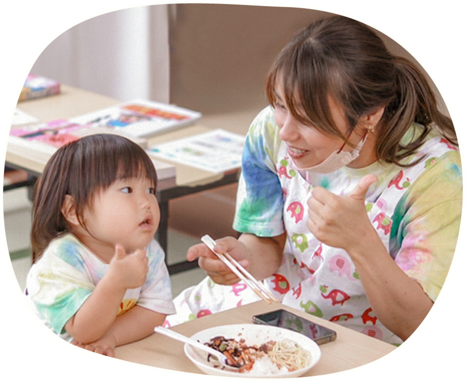 助産師と子供が笑顔で食事をする場面